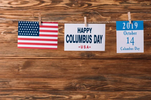 Card with happy Columbus day inscription near American national flag and calendar paper sheet with 14 October date on wooden surface — Stock Photo