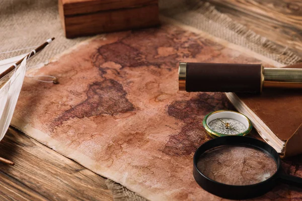 Карта світу біля телескопа і збільшення скла на дерев'яній поверхні — стокове фото