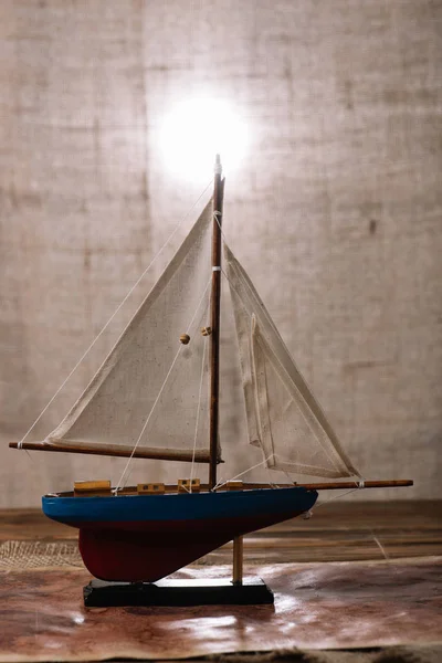 Navire décoratif avec voile blanche sur la surface en bois — Photo de stock