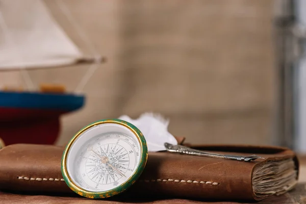 Compass near brown leather notebook with nib — Stock Photo