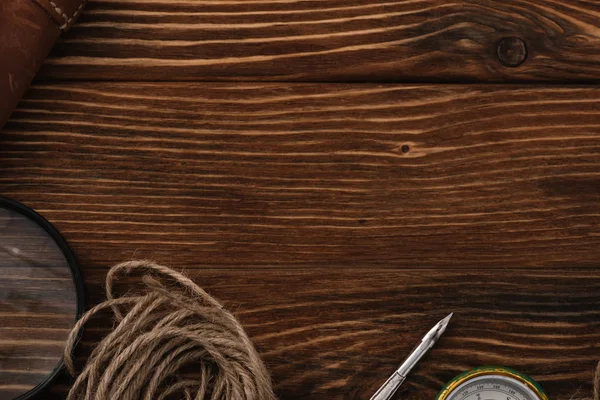 Draufsicht auf Schnur in der Nähe von Lupe, Feder und Kompass auf Holzoberfläche mit Kopierraum — Stockfoto