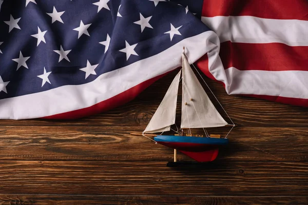 Vista superior do navio artesanal de couro na superfície de madeira com bandeira nacional americana — Fotografia de Stock