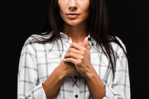 Cropped view of young woman with clenched hands isolated on black — Stock Photo