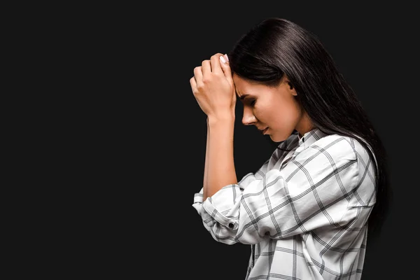 Side view of upset young woman touching head isolated on black — Stock Photo