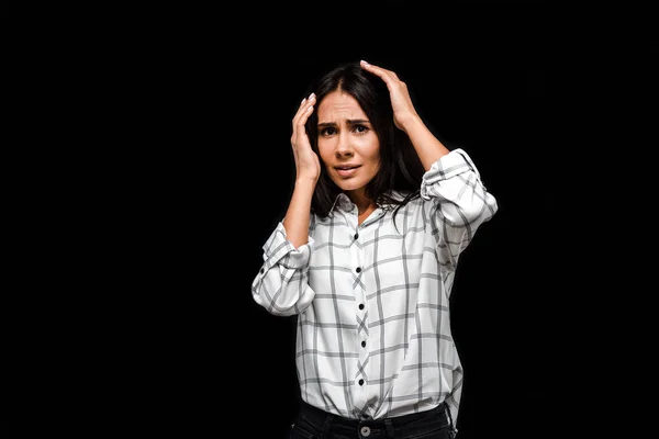 Upset young woman touching head isolated on black — Stock Photo