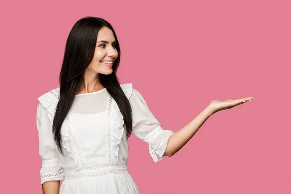 Mulher alegre no vestido gestual isolado no rosa — Fotografia de Stock