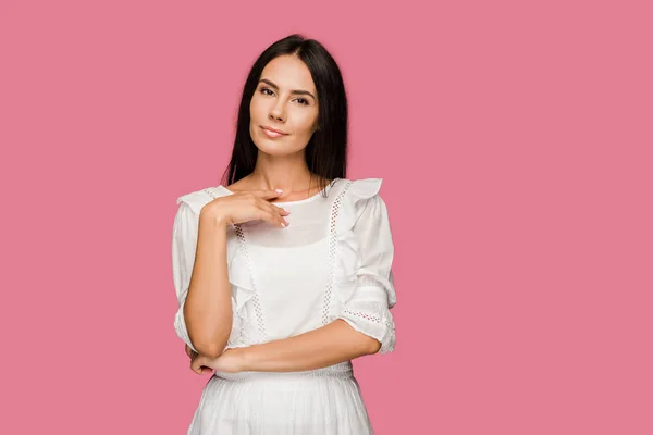 Atractiva mujer en vestido de pie y mirando a la cámara aislada en rosa - foto de stock