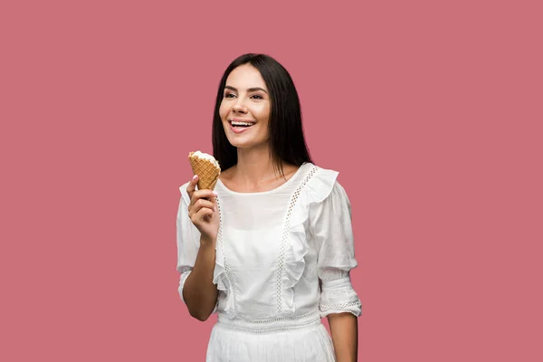 Allegra giovane donna in abito tenendo gustoso cono gelato isolato su rosa — Foto stock