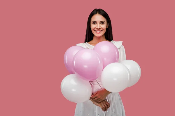 Alegre chica en vestido celebración globos aislado en rosa - foto de stock