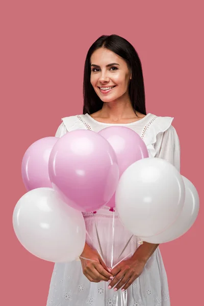 Chica feliz en vestido sosteniendo globos aislados en rosa — Stock Photo