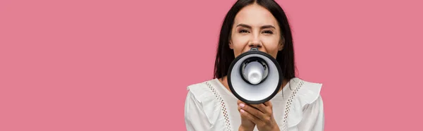 Panoramic shot of woman screaming in megaphone isolated on pink — Stock Photo
