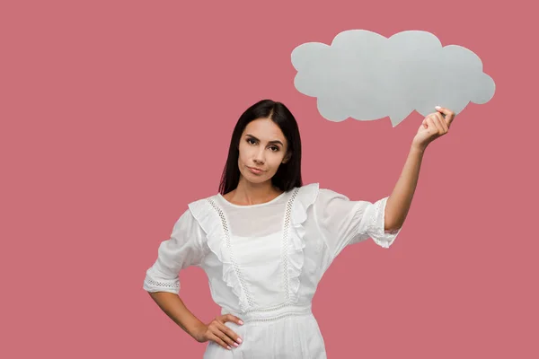 Displeased girl holding thought bubble and standing with hand on hip isolated on pink — Stock Photo