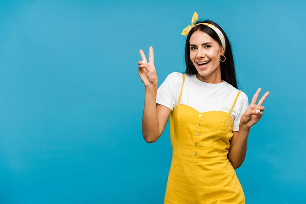 Happy woman woman showing peace signs isolated on blue — Stock Photo