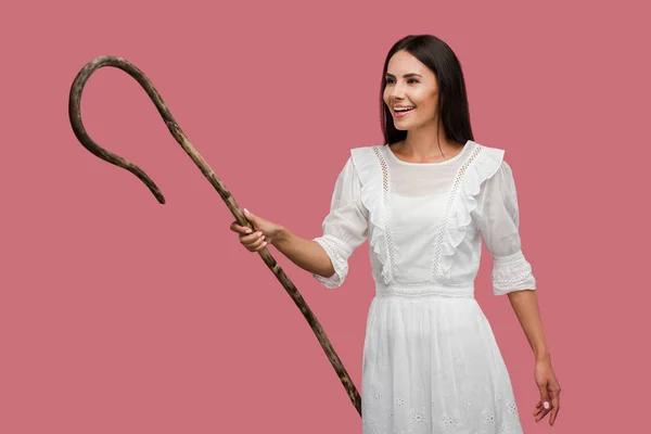 Happy young woman holding wooden cane isolated on pink — Stock Photo