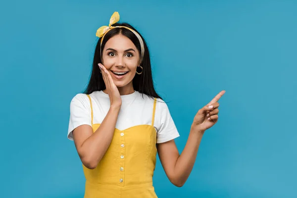 Aufgeregtes Mädchen zeigt mit dem Finger isoliert auf blau — Stockfoto