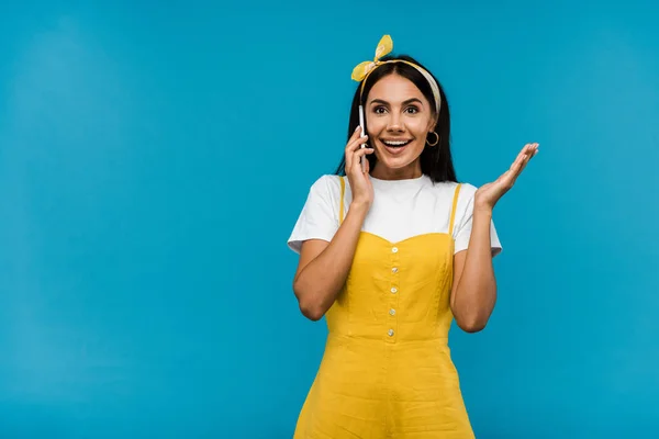 Femme heureuse parler sur smartphone et geste isolé sur bleu — Photo de stock