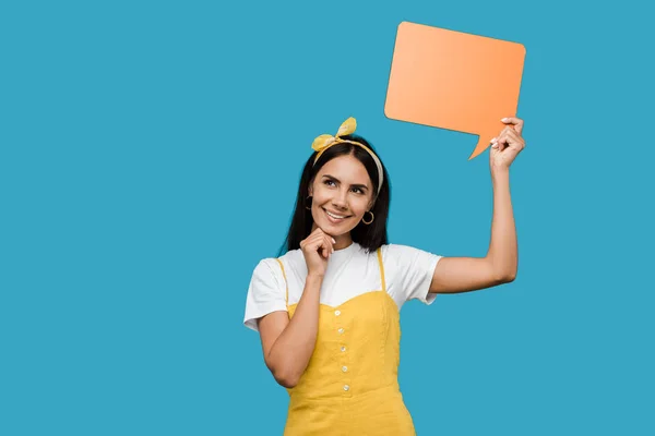 Feliz chica sosteniendo naranja discurso burbuja aislado en azul - foto de stock