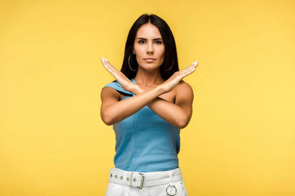 Atractiva mujer mostrando señal de stop con las manos aisladas en naranja - foto de stock