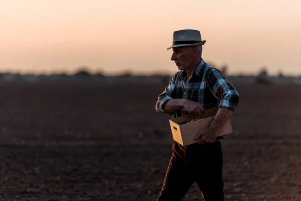 Agriculteur indépendant exploitation boîte dans le champ — Photo de stock