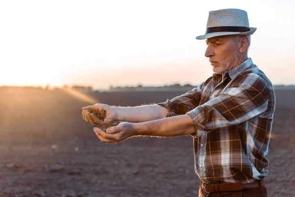 Agricultor independente em chapéu de palha semeando sementes à noite — Fotografia de Stock