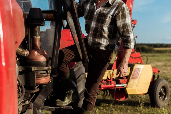 Селективний фокус на самозайнятому фермері, що стоїть біля сучасного трактора — стокове фото