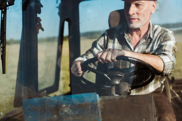 Bel lavoratore autonomo che sorride mentre guida il trattore — Foto stock