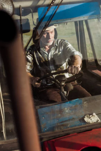 Messa a fuoco selettiva del bel lavoratore autonomo che sorride mentre guida il trattore — Foto stock