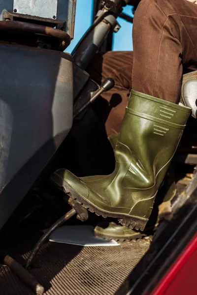 Cropped view of senior man driving tractor — Stock Photo