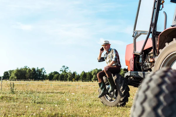 Fuoco selettivo dell'agronomo che parla su smartphone vicino al trattore — Foto stock