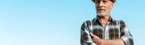 Panoramic shot of bearded farmer standing with crossed arms — Stock Photo