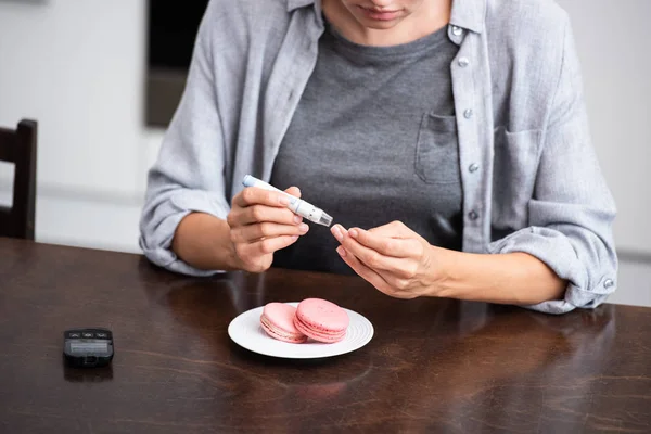 Vista ritagliata della donna che fa il test mentre tiene lancetta del sangue — Foto stock