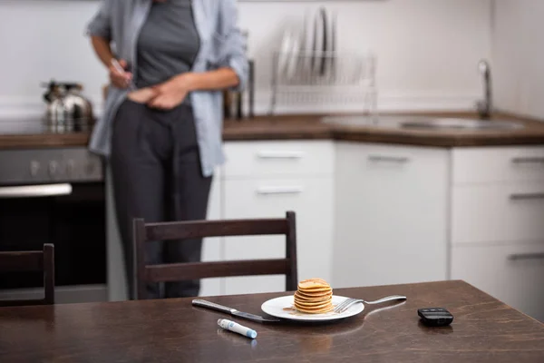 Foyer sélectif des crêpes près de l'équipement médical et la femme dans la cuisine — Photo de stock