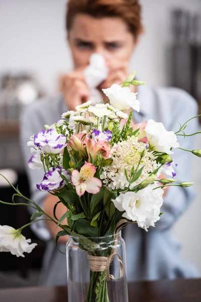 Fuoco selettivo di mazzo di fiori vicino a donna con allergia al polline — Foto stock