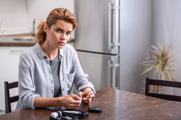 Attraente e sconvolto donna facendo esami del sangue a casa — Foto stock