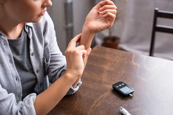 Ausgeschnittene Ansicht einer Frau, die Puls am Tisch überprüft — Stockfoto