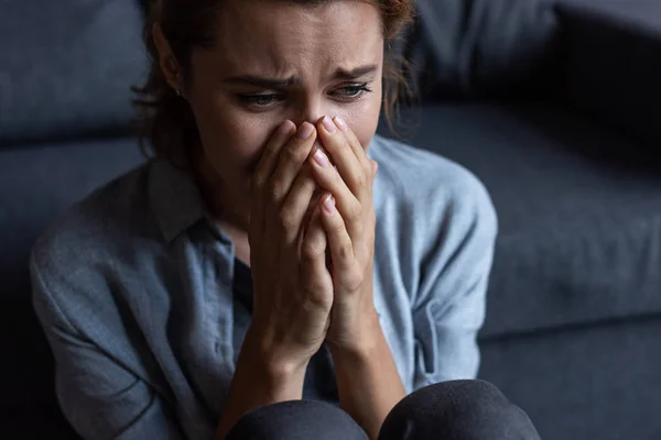 Засмучена жінка плаче і вкриває обличчя вдома — стокове фото