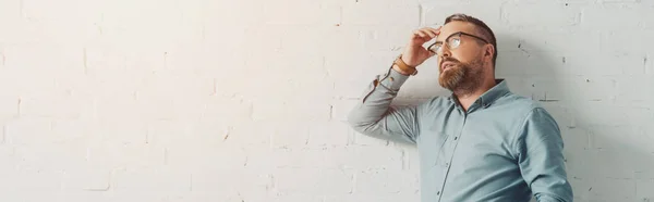 Panoramic shot of pensive businessman in shirt and glasses looking away — Stock Photo