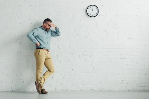 Pensive businessman in shirt and glasses looking down in office — Stock Photo