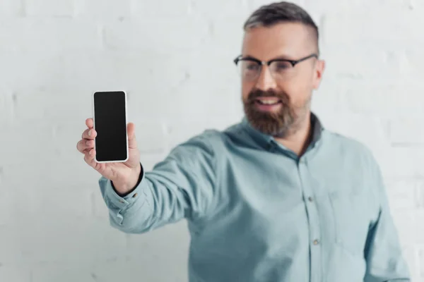 Selective focus of handsome businessman holding smartphone with copy space — Stock Photo