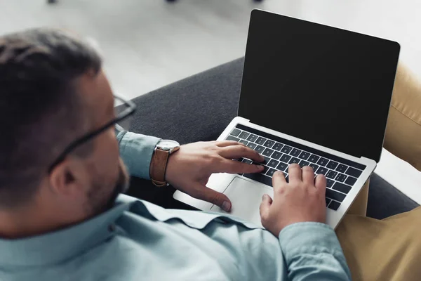 Vista ritagliata di uomo d'affari in camicia e occhiali utilizzando il computer portatile in ufficio — Foto stock
