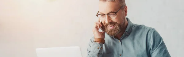 Панорамний знімок бізнесмена в сорочці і окулярах, що розмовляють на смартфоні — стокове фото