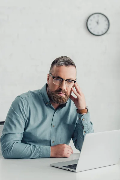 Gutaussehender Geschäftsmann in Hemd und Brille blickt in die Kamera — Stockfoto