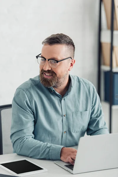 Schöner Geschäftsmann in Hemd und Brille mit Laptop im Büro — Stockfoto