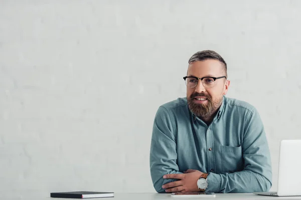 Handsome businessman in shirt and glasses looking away in office — Stock Photo