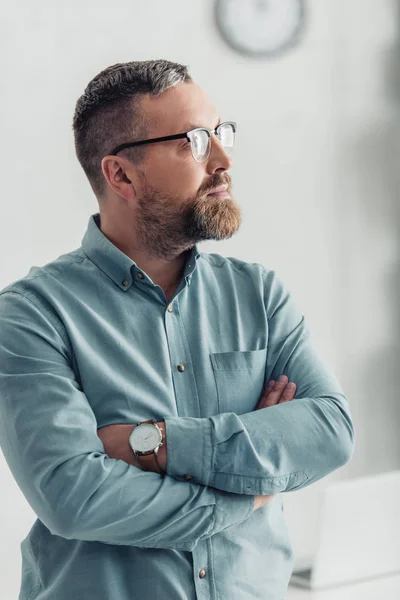 Bell'uomo d'affari in camicia e occhiali guardando lontano in ufficio — Foto stock