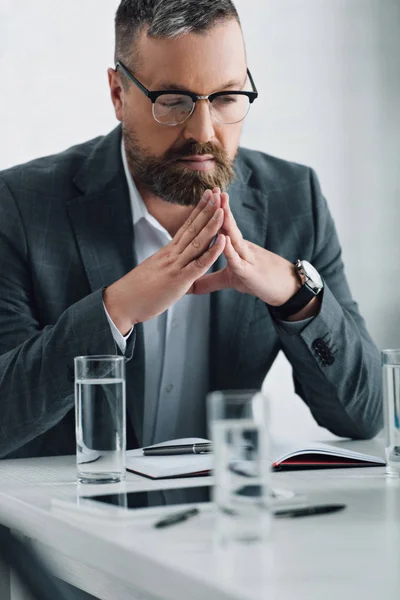 Bel homme d'affaires en tenue formelle et lunettes regardant loin dans le bureau — Photo de stock