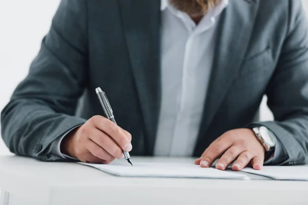 Vue recadrée de l'homme d'affaires dans l'écriture de vêtements formels avec stylo au bureau — Photo de stock