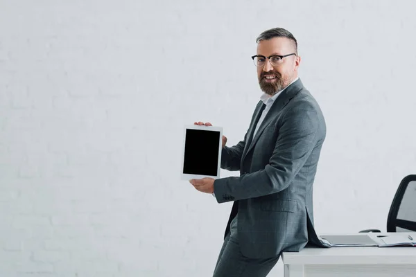 Guapo hombre de negocios en ropa formal sosteniendo tableta digital con espacio de copia - foto de stock