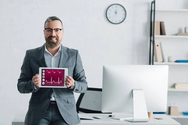 Bel homme d'affaires en tenue formelle tablette numérique avec site de santé — Photo de stock