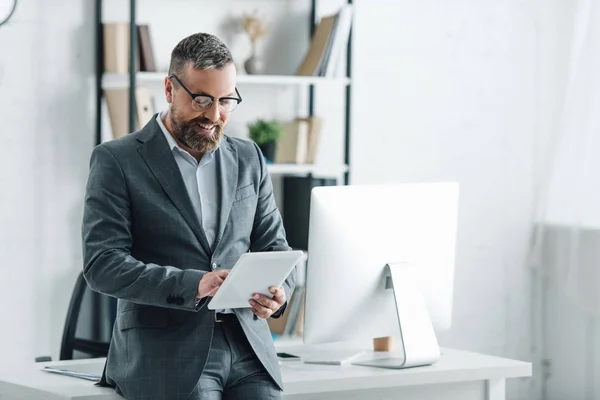 Schöner Geschäftsmann in formeller Kleidung mit digitalem Tablet im Büro — Stockfoto